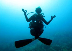 Photo of a diver doing a yoga pose underwater.
